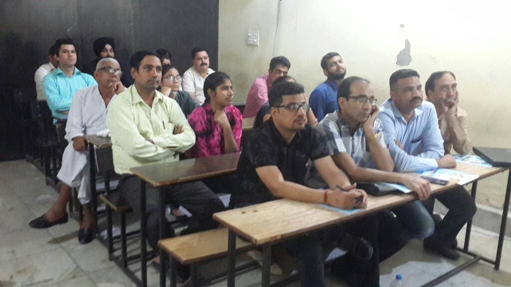Parents and students seated at desks during an information session