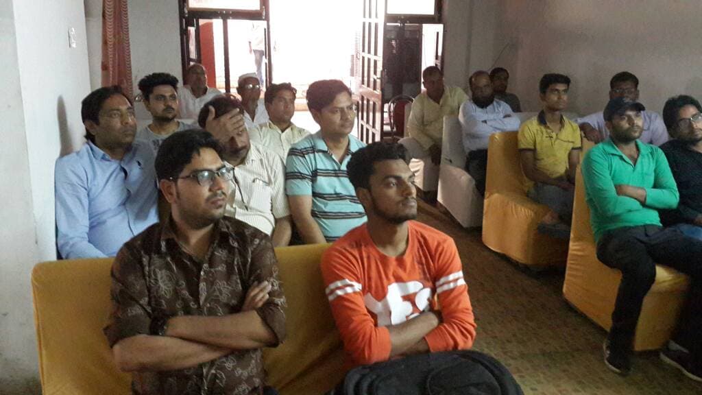 Attendees seated closely together, listening during an information session