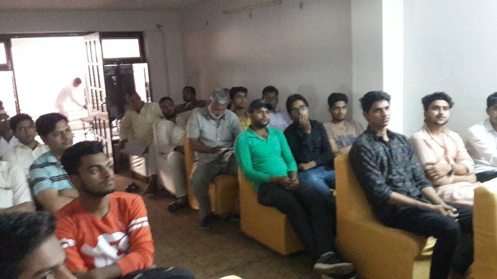 Students and parents seated together in a room, listening to a session